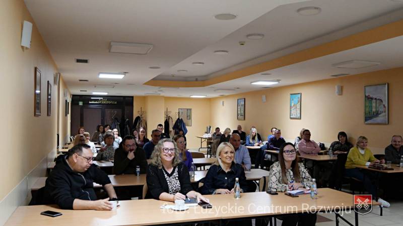 szkolenia urzędników, grupa osób siedzących w ławkach w sali konferencyjnej